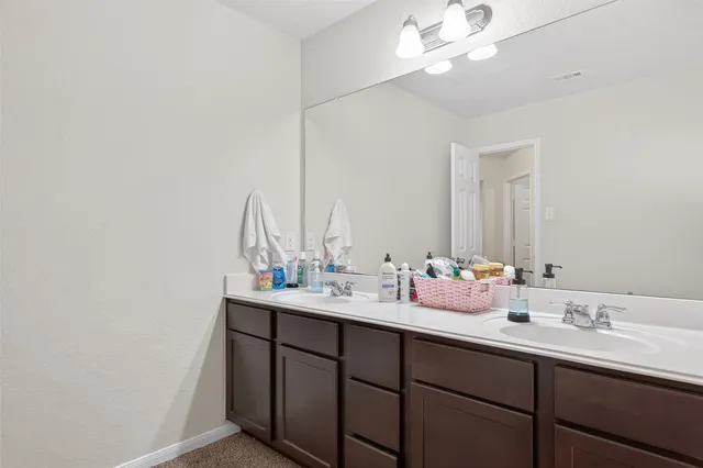 a bathroom with a double vanity sink and a mirror