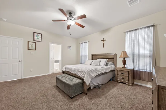 a spacious bedroom with a bed and a chandelier