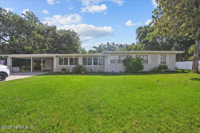 a view of house with backyard outdoor seating and green space