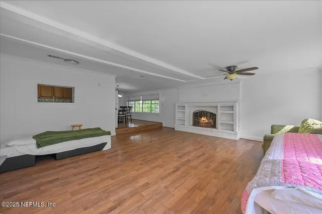 a view of a room with wooden floor and a fireplace