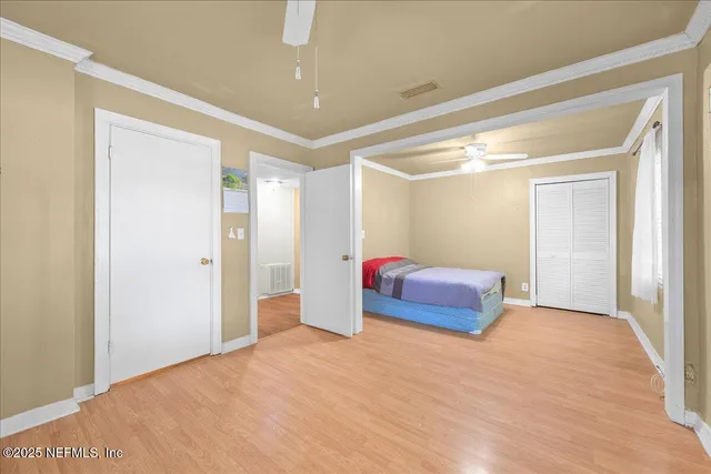 a spacious bedroom with a bed and a chandelier