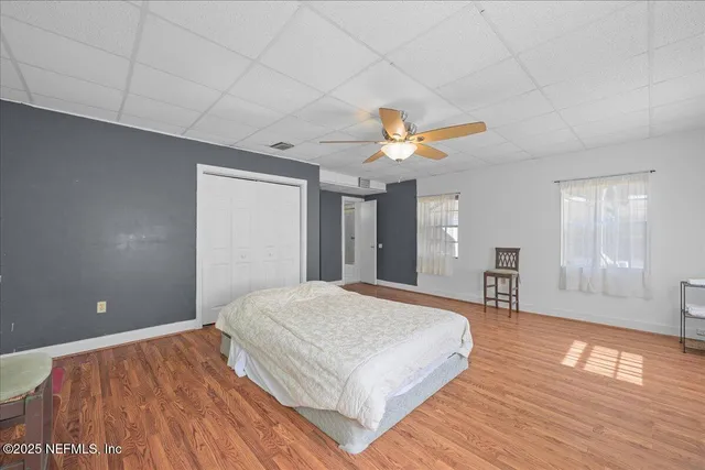 a bedroom with a large bed chandelier and a window