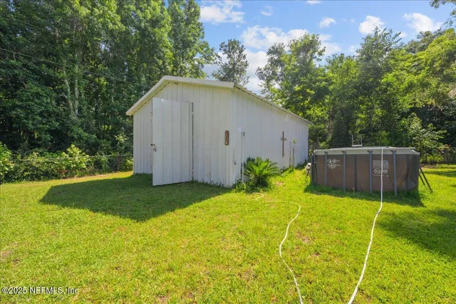 a backyard of house with plants and large tree