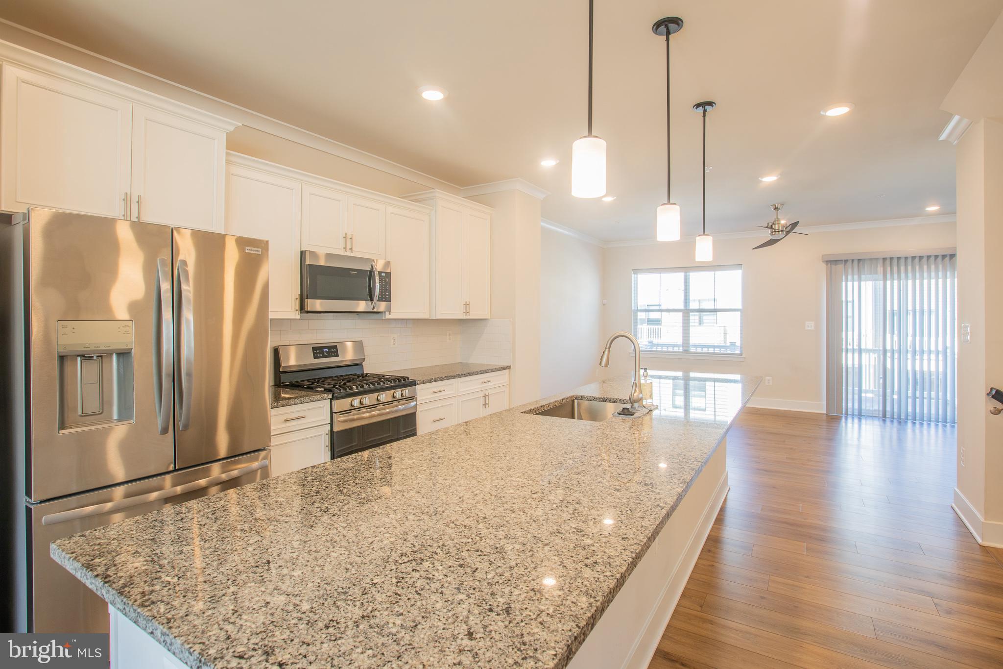 826 Teacher MItchell Road Glen Burnie, MD 21060 - Photo 15 of 41 a kitchen with stainless steel appliances granite countertop a refrigerator a sink a stove and a wooden floor