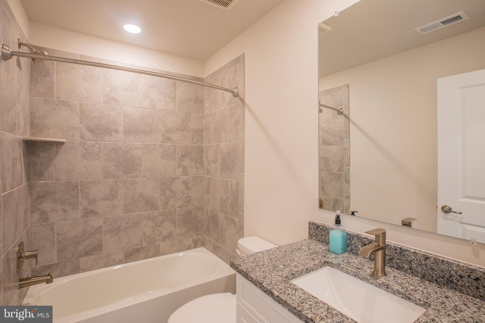 826 Teacher MItchell Road Glen Burnie, MD 21060 - Photo 21 of 41 a bathroom with a granite countertop tub sink and mirror