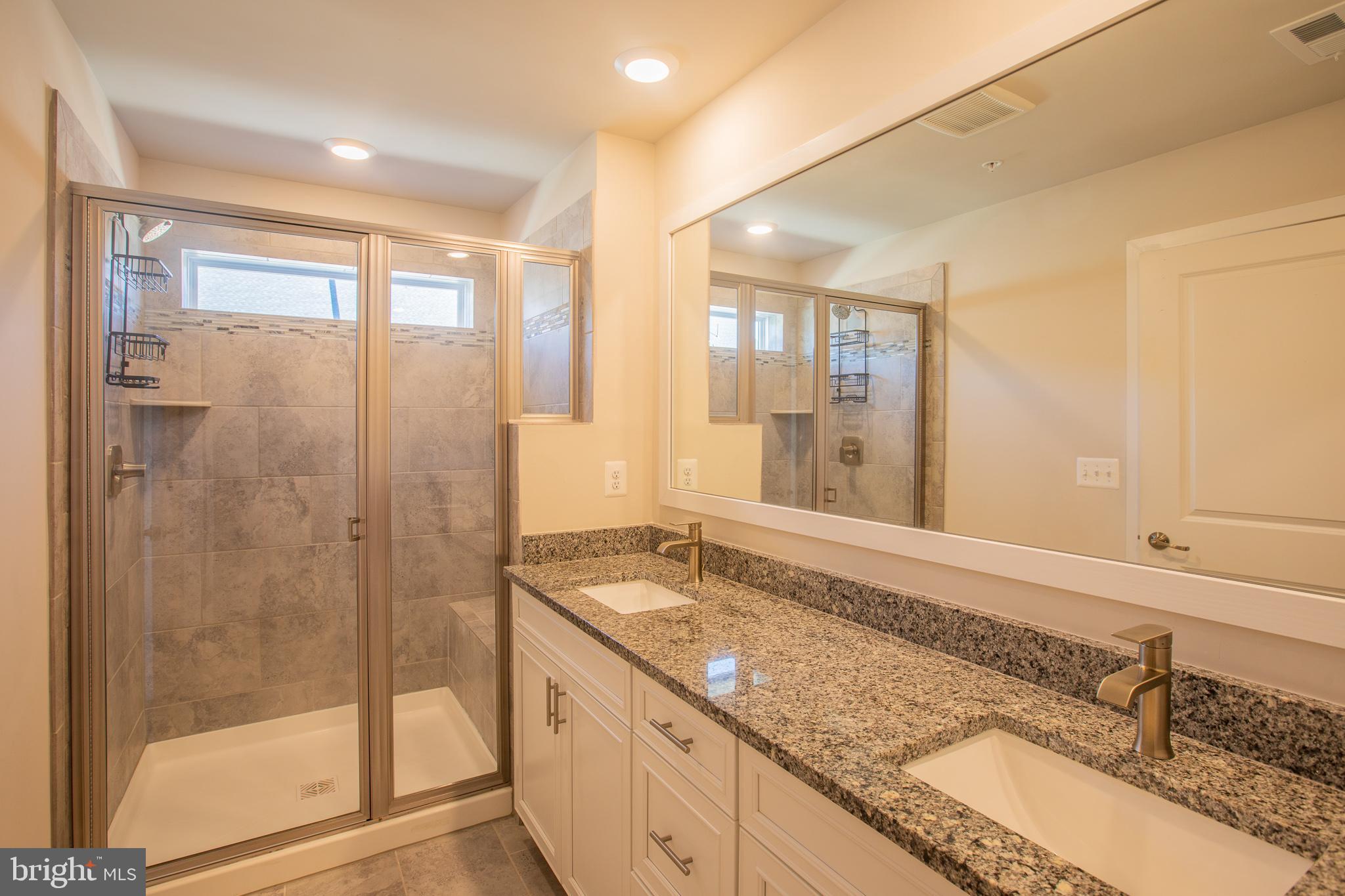 826 Teacher MItchell Road Glen Burnie, MD 21060 - Photo 29 of 41 a bathroom with a granite countertop sink mirror and a shower