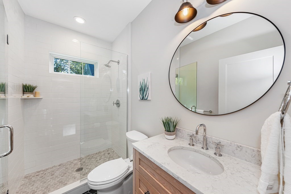 37 Woodland Road Lexington, MA 02420 - Photo 17 of 40 a bathroom with a sink a toilet and a mirror