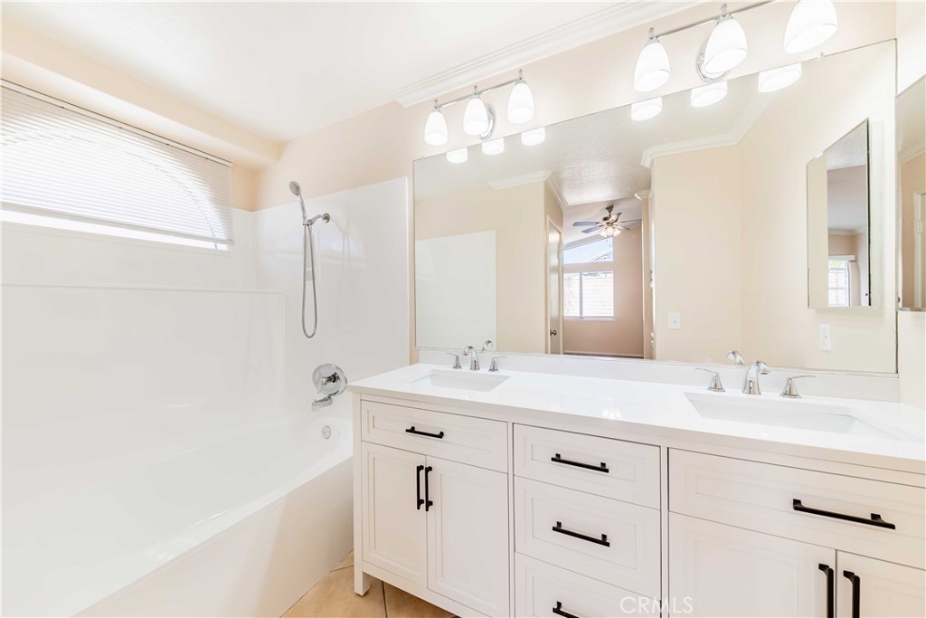 40048 Villa Venecia Temecula, CA 92591 - Photo 16 of 36 a bathroom with a double vanity sink a mirror and a bathtub
