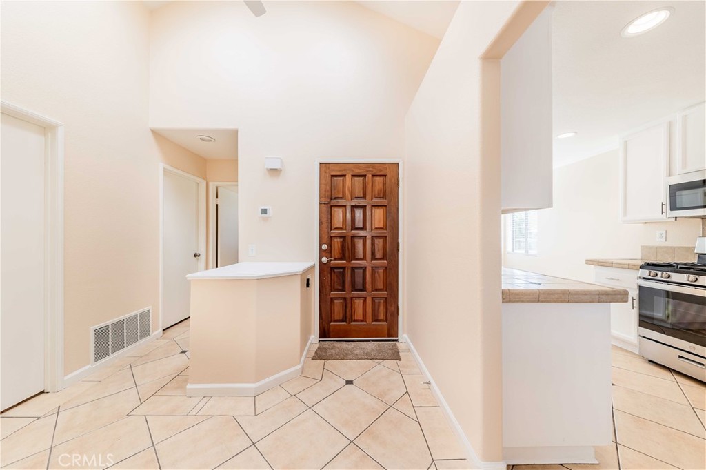 40048 Villa Venecia Temecula, CA 92591 - Photo 5 of 36 a kitchen with granite countertop white cabinets and white appliances