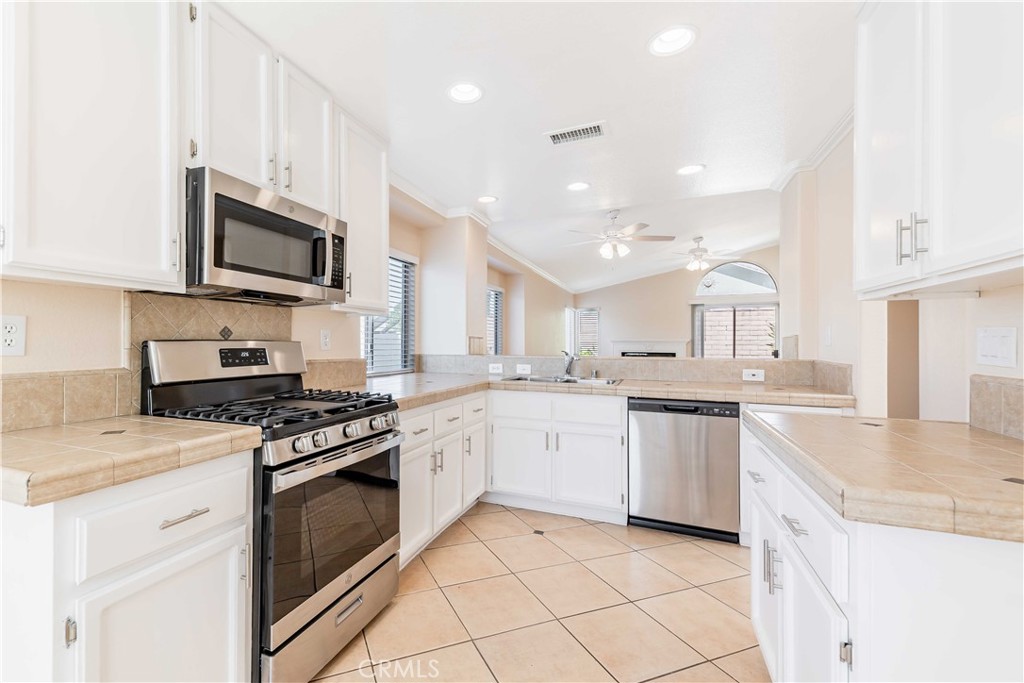 40048 Villa Venecia Temecula, CA 92591 - Photo 8 of 36 a kitchen with granite countertop stainless steel appliances a stove sink microwave and cabinets