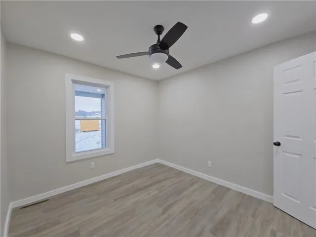 an empty room with a window and a ceiling fan
