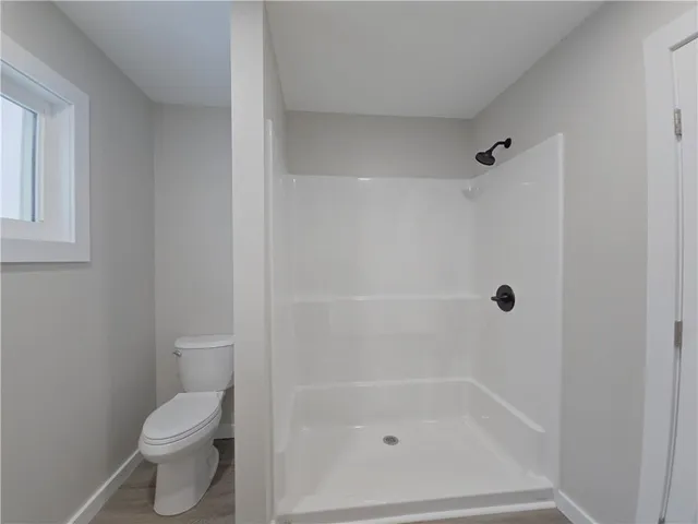 a bathroom with a toilet and a shower