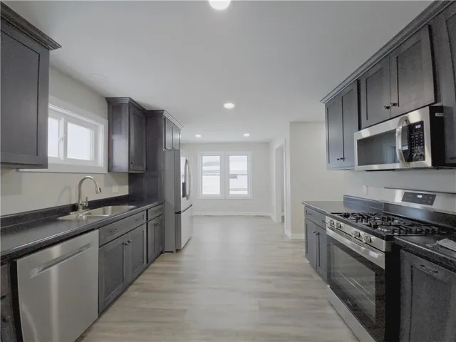 a kitchen with stainless steel appliances a sink stove and cabinets