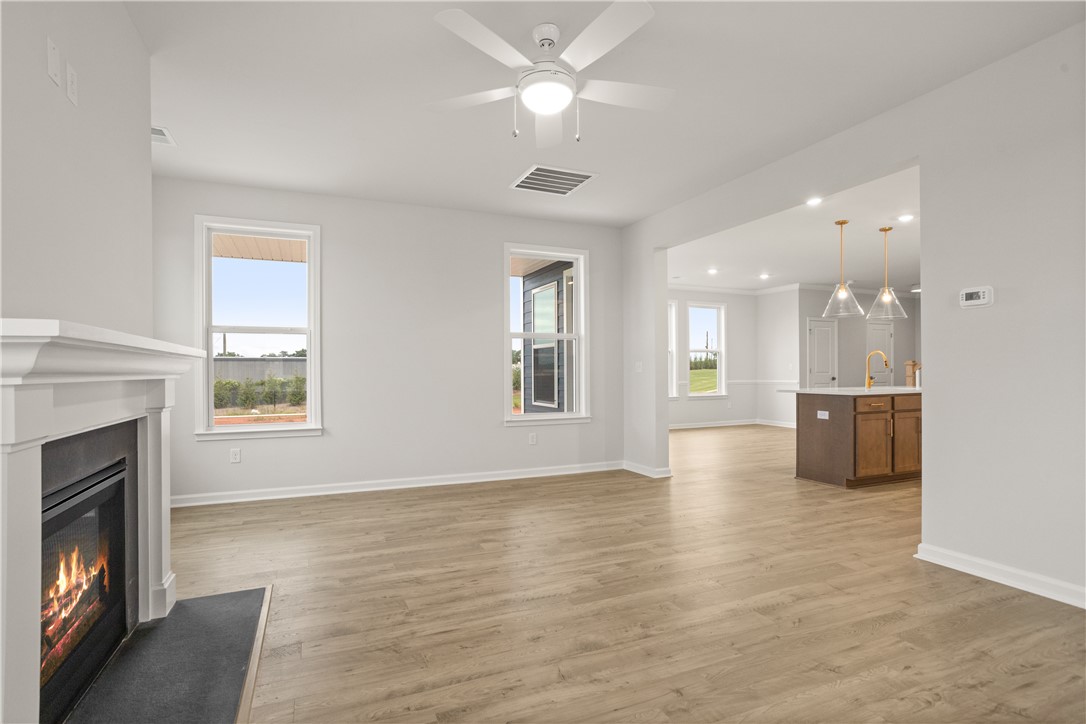 631 Sweetspire Trail, Unit 148 Seneca, SC 29678 - Photo 12 of 36 A fireplace provides warmth in this living area, featuring light wood flooring and an open view into the kitchen.