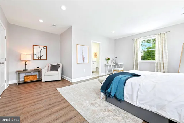 a spacious bedroom with a bed a table and a large window