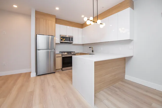 a kitchen with stainless steel appliances a refrigerator sink and stove