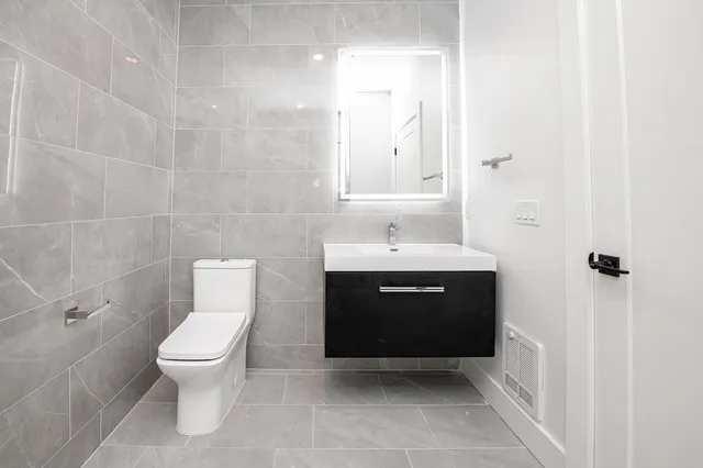 a spacious bathroom with a toilet sink and mirror