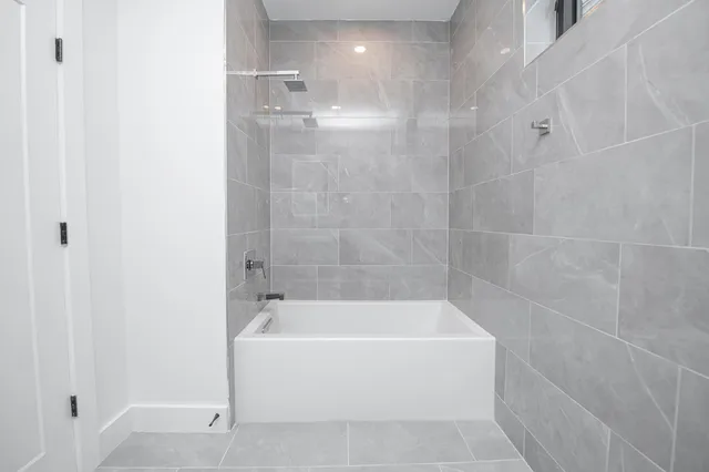 a white bath tub sitting next to a shower