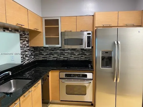 a kitchen with a sink a refrigerator and cabinets