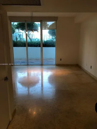 a view of empty room with floor to ceiling window and plants