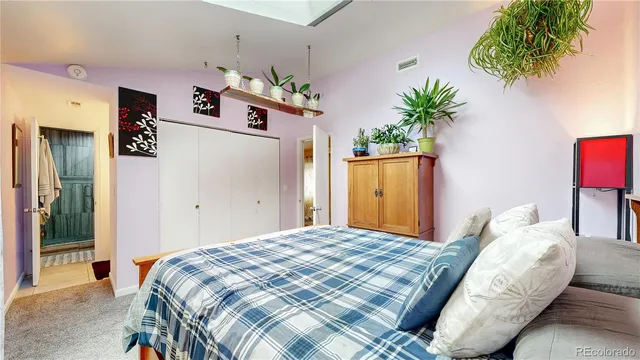 a bedroom with a bed and a potted plant
