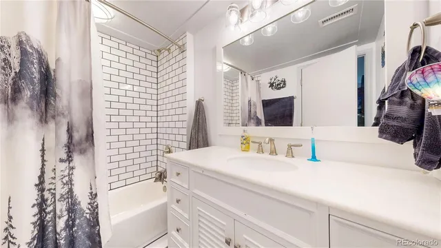 a bathroom with a granite countertop sink a large mirror and shower
