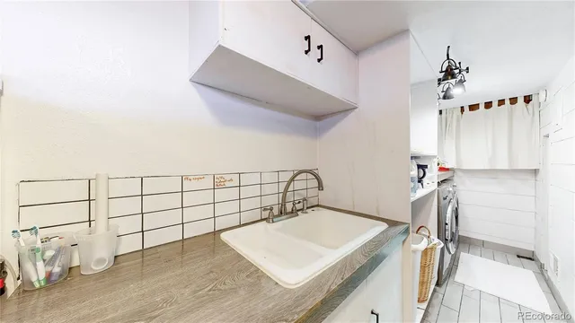 a view of a hallway with a white cabinet and a chandelier