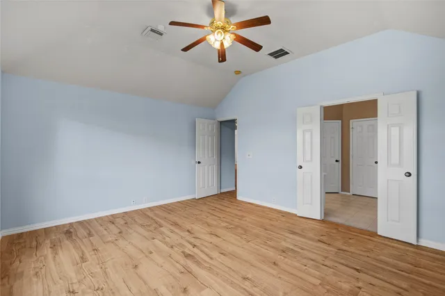 a view of empty room with wooden floor