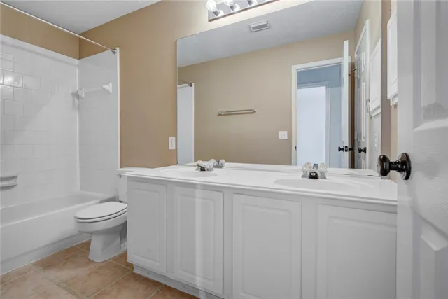 a bathroom with a double vanity sink toilet and a mirror