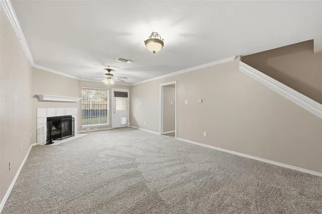 a view of an empty room with a fireplace and a window