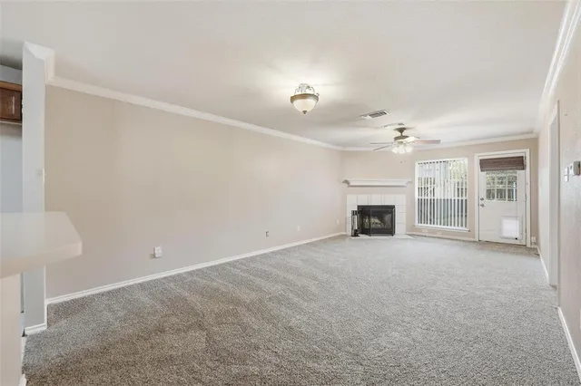 a view of an empty room with chandelier and fireplace