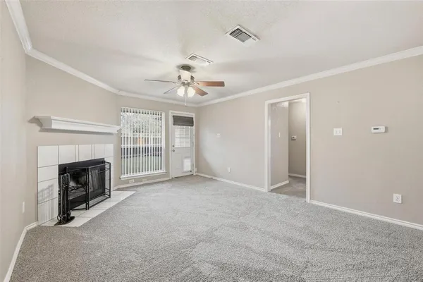 a view of an empty room with a fireplace and a window
