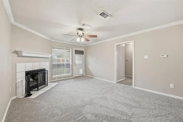 a view of an empty room with a fireplace and a window