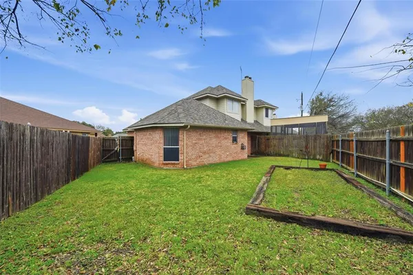 a view of a backyard with a garden and entertaining space