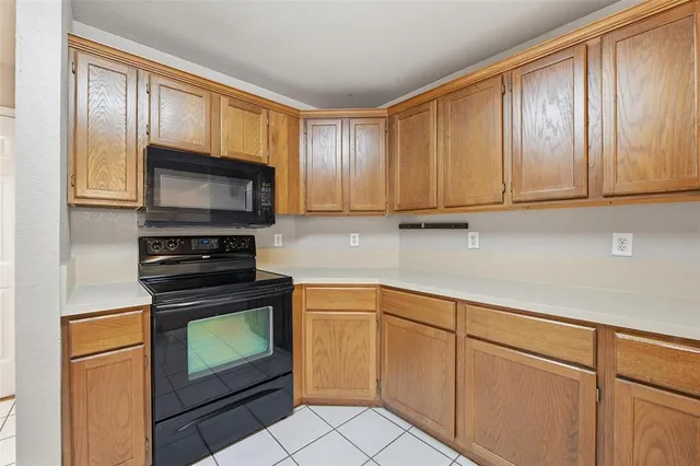 a kitchen with granite countertop wooden cabinets stainless steel appliances and a window