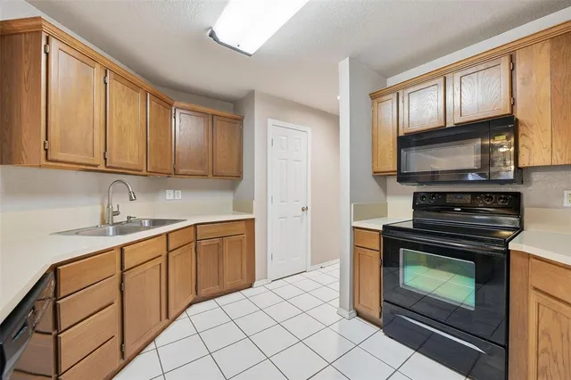 a kitchen with granite countertop a stove top oven microwave and cabinets