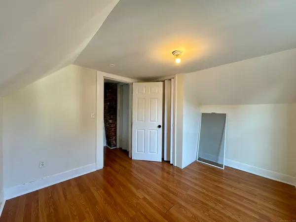 a view of empty room with wooden floor