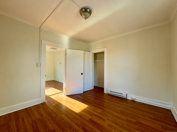 a view of an empty room with wooden floor