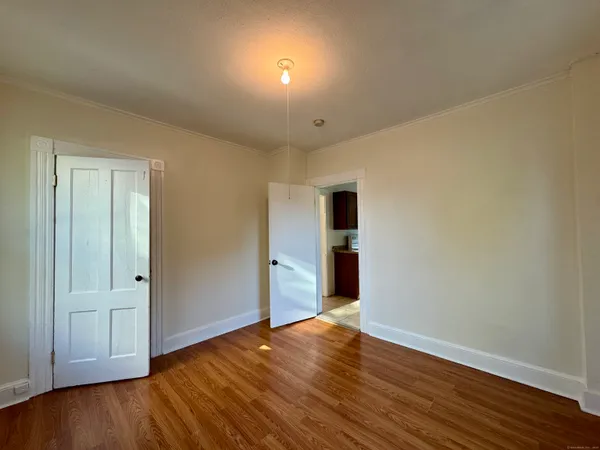 a view of an empty room with wooden floor