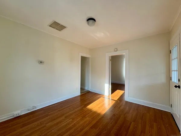 a view of empty room with wooden floor