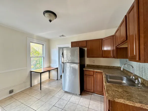 a kitchen with a sink a refrigerator and wooden cabinets