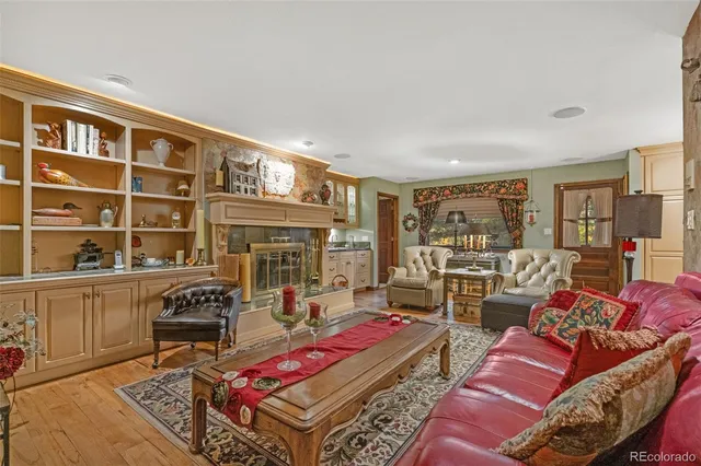 a living room with furniture a wooden floor and next to a window