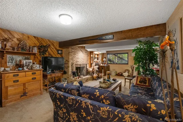 a living room with furniture a large window and a fireplace