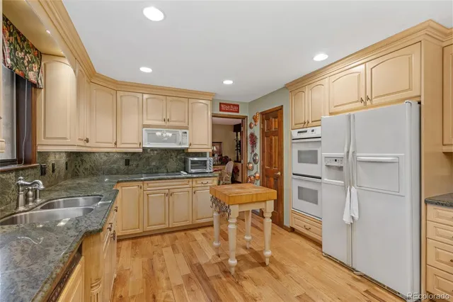 a kitchen with granite countertop appliances cabinets and a sink