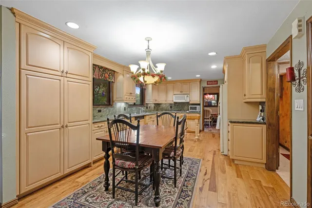 a kitchen with refrigerator and wooden floor