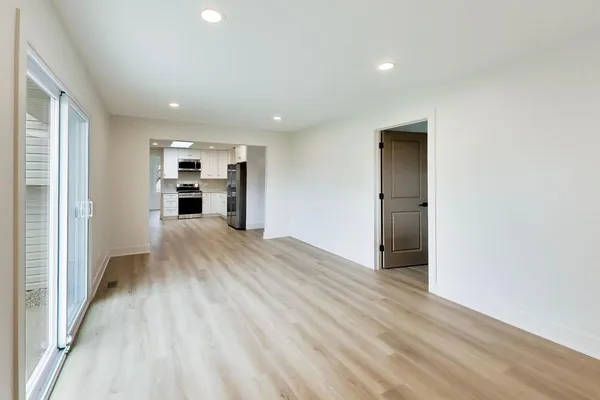 a view of empty room with wooden floor