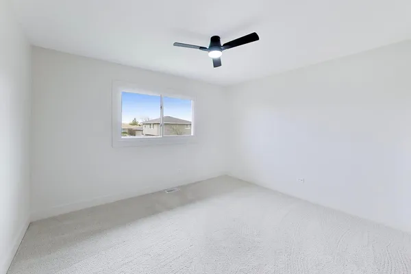 an empty room with a ceiling fan and window