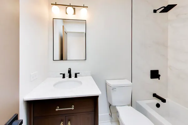 a bathroom with a sink a toilet and mirror