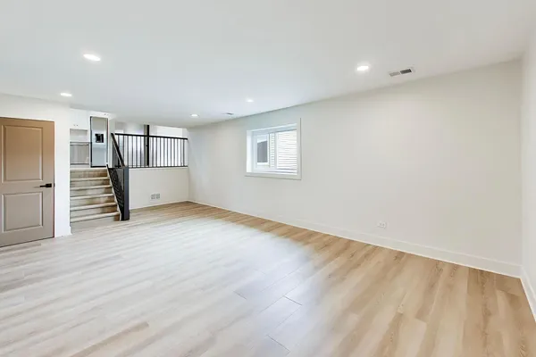 a view of empty room with wooden floor