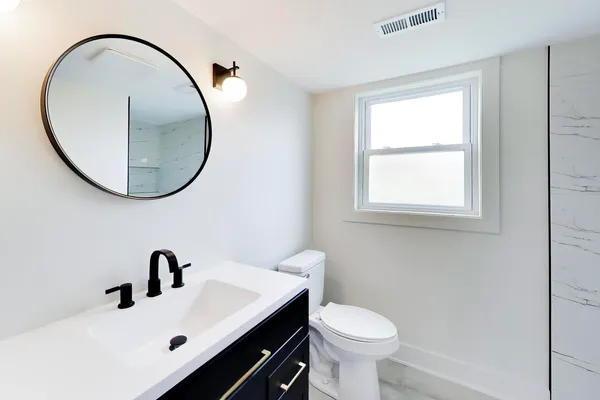 a bathroom with a sink mirror and toilet